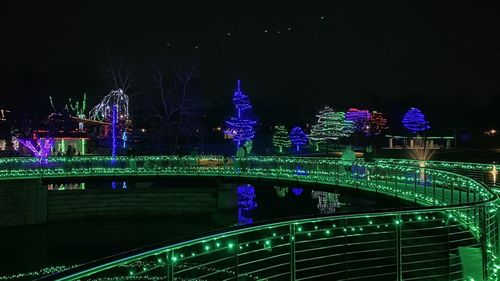 Illuminated bridge over river at night