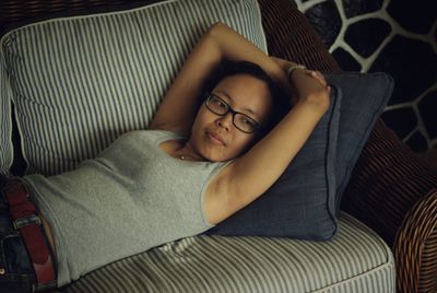 High angle view of young woman lying on sofa