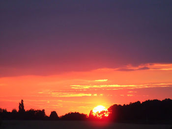 Scenic view of silhouette trees against romantic sky at sunset