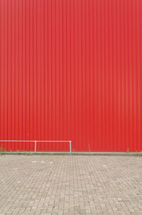 Empty walkway against red wall