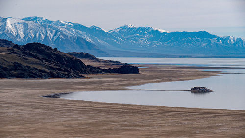 Scenic view of sea and mountains against sky