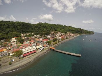 High angle view of town by sea against sky