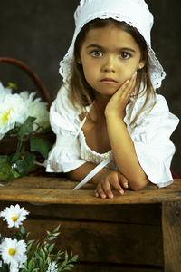Portrait of a girl with red flower on table