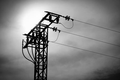 Low angle view silhouette of electricity pylon against sky