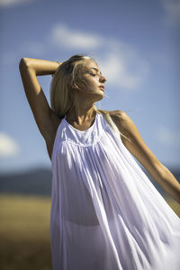 Young woman with closed eyes standing on field