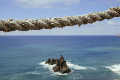 Close-up of rocks on beach against sky