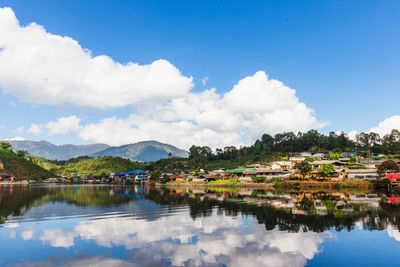 Scenic view of lake by buildings against sky