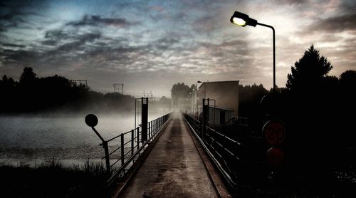 View of road against cloudy sky at dusk