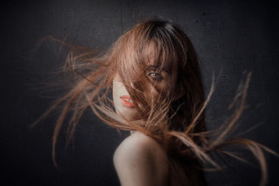 Portrait of a beautiful young woman over black background