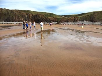 People at beach against sky