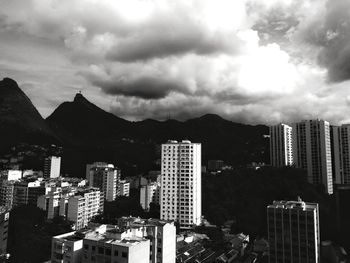 View of cityscape against cloudy sky