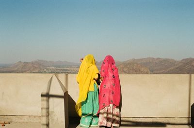 Women in traditional clothing standing on terrace