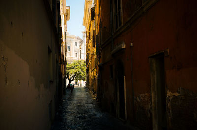 Empty alley amidst old buildings in city