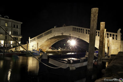 Bridge over canal in city at night