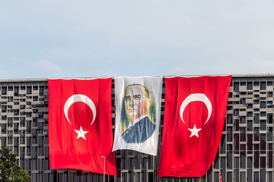 Red flag against buildings in city against sky