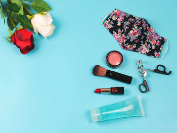 High angle view of roses on table against blue background