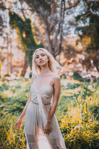 Young woman standing against plants