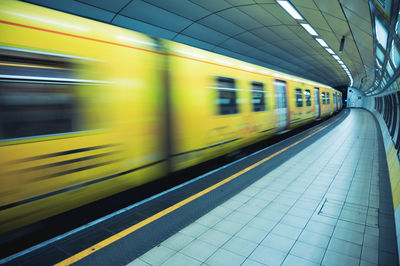 Blurred motion of train at railroad station