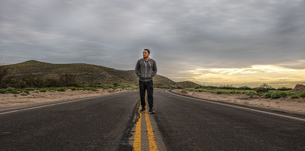 Man standing on road against sky