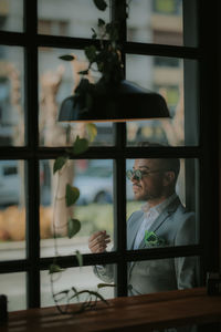 Portrait of man seen through glass window