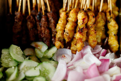 Close-up of roasted meat with sliced onions and cucumbers