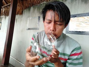 Portrait of young man drinking glass