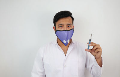 Portrait of man standing against white background