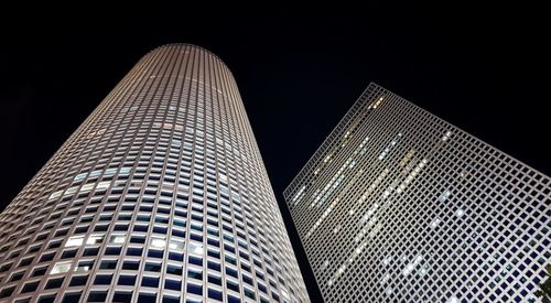 Low angle view of illuminated buildings against clear sky at night