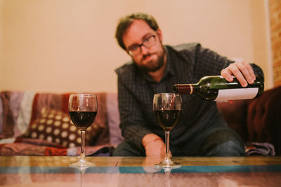 Man drinking glasses on table