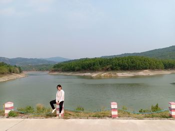 Rear view of man on lake against sky