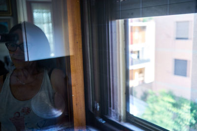 Reflection of man on window at home