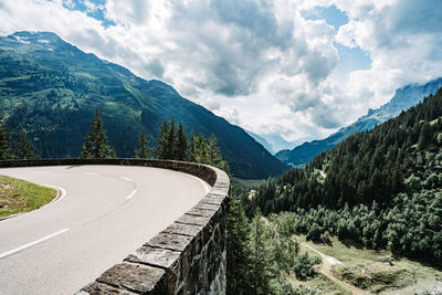 Scenic view of road by mountains against sky