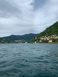 Scenic view of sea by townscape against sky