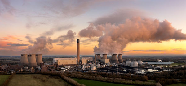 Aerial landscape of coal fired power station at sunset with coal stack and biofuel storage tanks