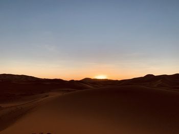 Scenic view of desert against sky during sunset