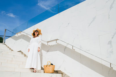 Woman standing on white wall