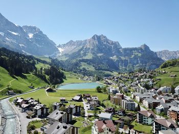 Aerial view of townscape by mountains against clear sky