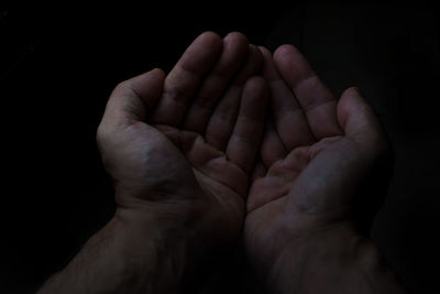 Cropped hands against black background