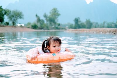 Portrait of girl in swimming with tube at river
