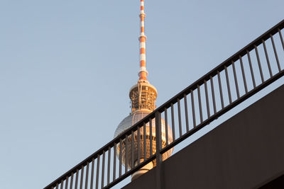 Low angle view of the berlin television tower behind a bridge against the clear sky