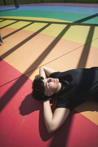 Young woman lying on colorful ground