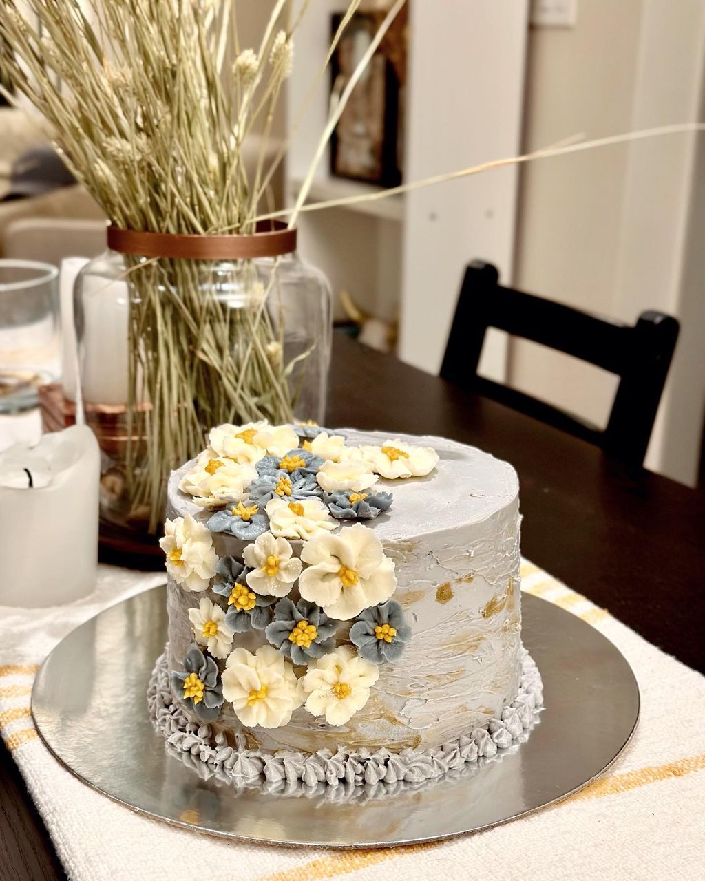 food and drink, birthday cake, wedding cake, table, food, flower, flowering plant, indoors, plant, freshness, yellow, no people, cake, decoration, icing, nature, centrepiece, sweet food, dessert, meal, celebration, home interior, baked, plate, sweet, chair, seat, domestic room, still life, event, vase