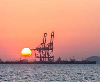 Silhouette of crane against sky during sunset