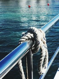 Close-up of rope tied to boat sailing in sea