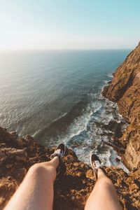 Low section of man on beach against clear sky