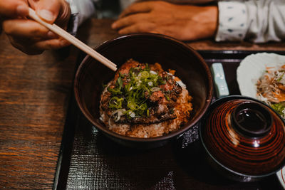 Midsection of person having food on table