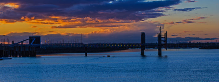 Pier over sea against sky during sunset