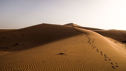 Sand dunes in desert against clear sky