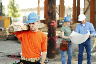 Portrait of male construction worker with two construction worke