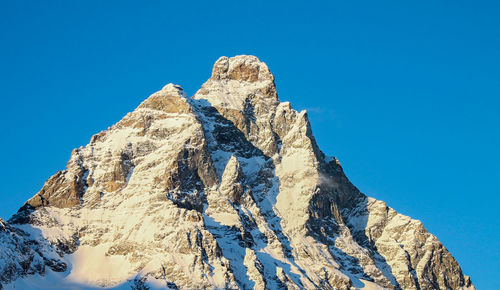 Low angle view of mountain peak against clear blue sky